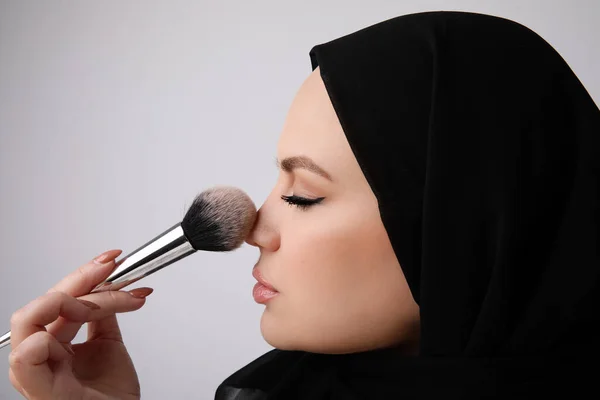 Close-up de jovem bela mulher arabe vestindo hijab islâmico fazendo sua maquiagem — Fotografia de Stock