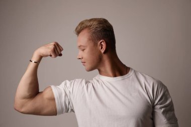 Kaslı genç adam kaslarını gösteriyor. Yaşam tarzı ve vücut geliştirme.