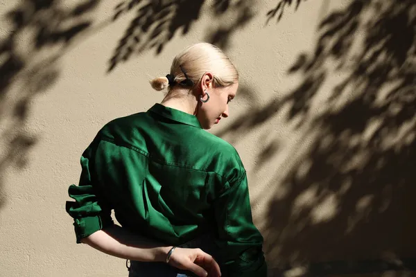 금발 머리 여자가 초록색 셔츠를 입고 밖에서 포즈를 취하는 모습. — 스톡 사진