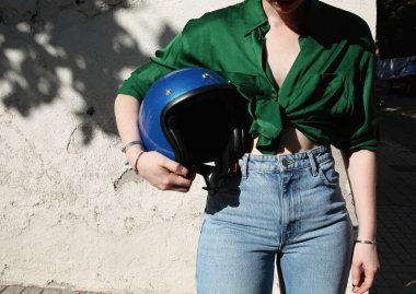 Mavi kotla poz veren kıvrımlı beyaz bisikletli bir kadının kesilmiş fotoğrafı. Açık hava..