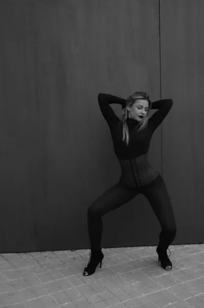 Foto vertical de una hermosa joven en movimiento de baile. Al aire libre. Blanco y negro — Foto de Stock