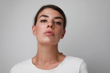 Düşüncelere dalmış üzgün genç bir kadın, kameraya bakıyor..