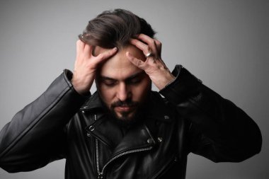 Üzgün ve üzgün sakallı genç adam, beyaz arka planda poz veriyor..