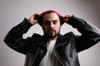 Yakışıklı, sakallı, kendine güvenen, beyaz duvarın üstünde poz veren bir adam. İzole edilmiş.