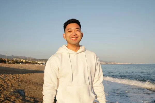 Feliz guapo sonriente joven asiático hombre, posando al aire libre. — Foto de Stock