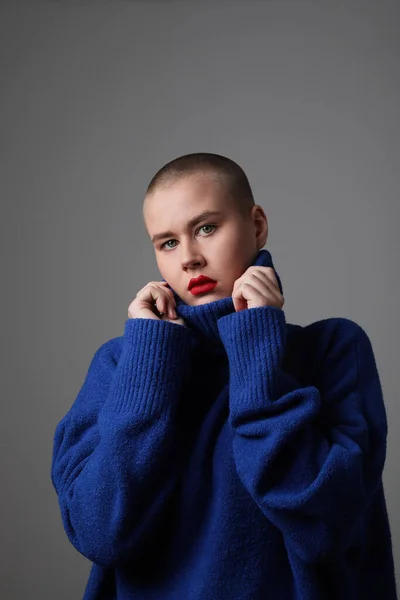Vertikales Porträt einer schönen jungen Frau mit Glatze, die einen blauen Pullover trägt. Isoliert. — Stockfoto
