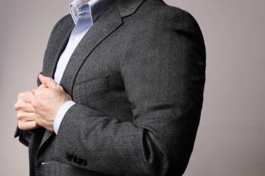 Kesilmiş iş adamı imajı, kendine güveni olan, beyaz duvarın üzerinde poz veren.