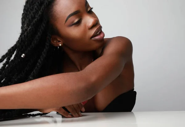 Magabiztos fekete afrikai fiatal nő fonatokkal félrenéz. Elszigetelt. — Stock Fotó