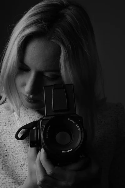 Vertical black and white portrait of young woman with analog old camera. — Stock Photo, Image