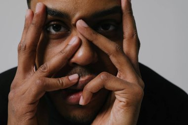 Dişetleri ağrıyan Afro-Amerikalı genç bir adam. Yüzüne dokunuyor..