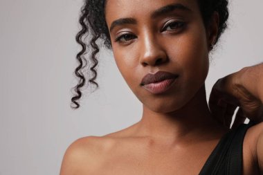 Beyaz arka planda poz veren kendine güvenen siyah afro kadın. Kadın Sağlığı.