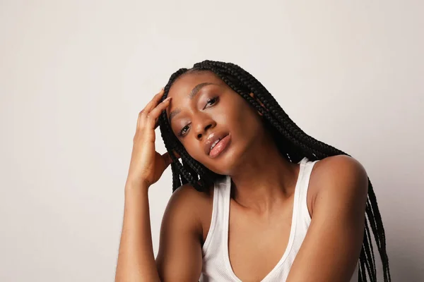 Portret młodej afro amerykańskiej kobiety z lśniącą skórą i długimi warkoczami. — Zdjęcie stockowe