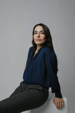 Esmer, orta yaşlı, gülümseyen ve kameraya bakan bir kadın. Dikey.