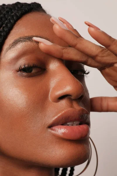 Close-up de uma jovem negra bonita com maquiagem natural olha para a câmera. — Fotografia de Stock