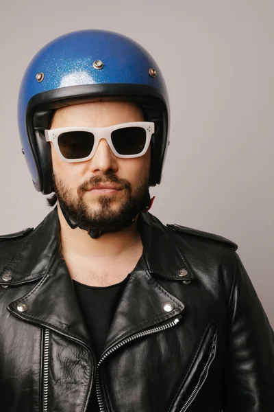 Potret vertikal dari pria berjenggot biker dengan jaket kulit dan helm biru retro. — Stok Foto