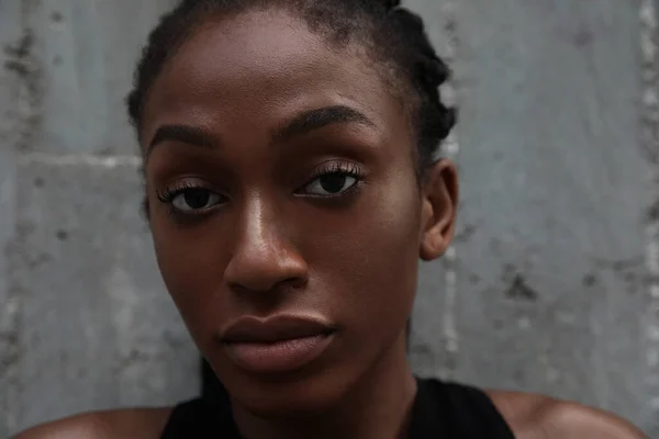 Close-up dari wanita afro percaya diri dengan rambut dikepang hitam berpose di dinding gelap. — Stok Foto