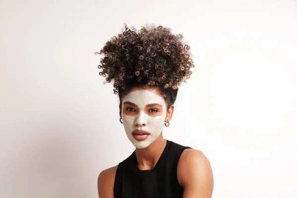Piękna kobieta stosuje nawilżającą maskę do twarzy, pielęgnuje odizolowane piękno skóry. — Zdjęcie stockowe