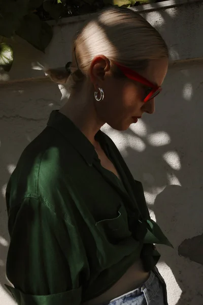 Profil-Porträt einer jungen blonden Frau, die im Freien posiert, dunkle Belichtung. — Stockfoto