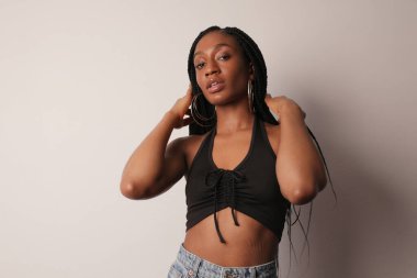 Kendinden emin, Afro-Amerikan güzel bir kadın. Parlak tenli ve uzun örgülü..