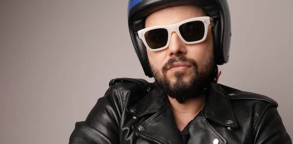 Foto close-up biker berjenggot mengenakan jaket kulit mengenakan helm sepeda motor. — Stok Foto
