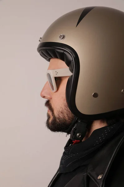 Potret vertikal dari biker berjenggot berpose dalam jaket kulit dan helm retro. — Stok Foto