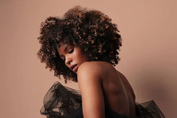 Temiz kıvırcık kahverengi saçlı, bej arka planda Afro-Amerikalı bir kadın.. — Stok fotoğraf