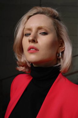 Siyah arka planda poz veren genç bir kadının açık hava portresi. Dikey.