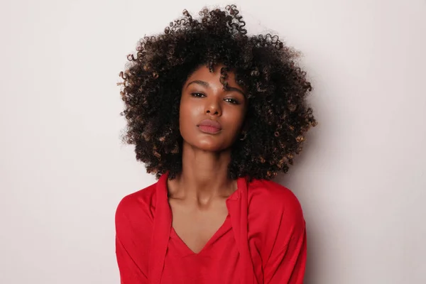 Jovem mulher bonita com cabelos castanhos encaracolados posando no fundo branco. — Fotografia de Stock