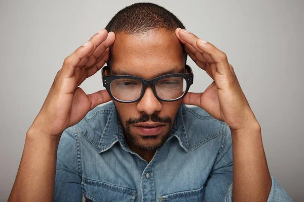 Komoly fekete fiatalember mentális problémákkal. Megérintette a fejét a fehér falon. — Stock Fotó