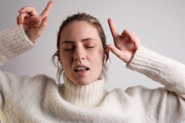 Kulaklıklı, gözleri kapalı müzik dinleyen mutlu genç bir kadın. İzole edilmiş.