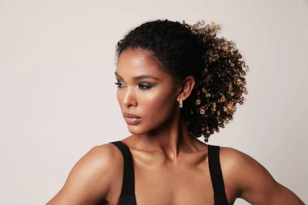 Beautiful African American young woman with curly black hair looking away. — Stock Photo, Image