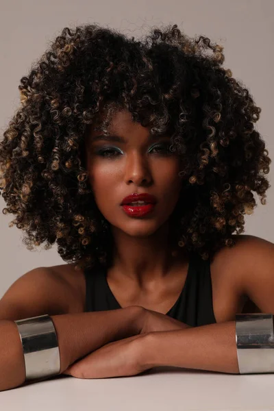 Beautiful African American young woman with curly black hair posing on white. — Stock Photo, Image