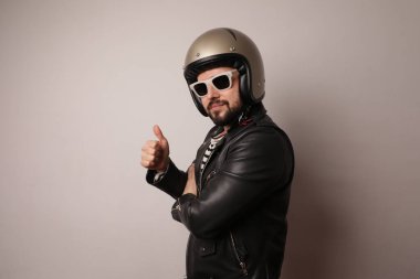 Motosikletli yakışıklı bir adam tamam işareti yapıyor ve kameraya bakıyor. İzole edilmiş.