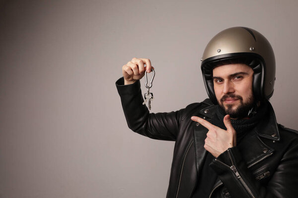 Bearded biker man posing with motorcycle keys on white background. Isolated.