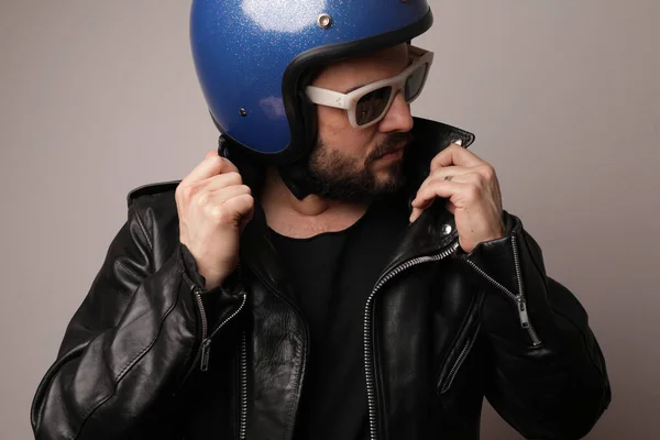 Biker berpose dengan jaket kulit dan helm motor biru. Terisolasi. — Stok Foto