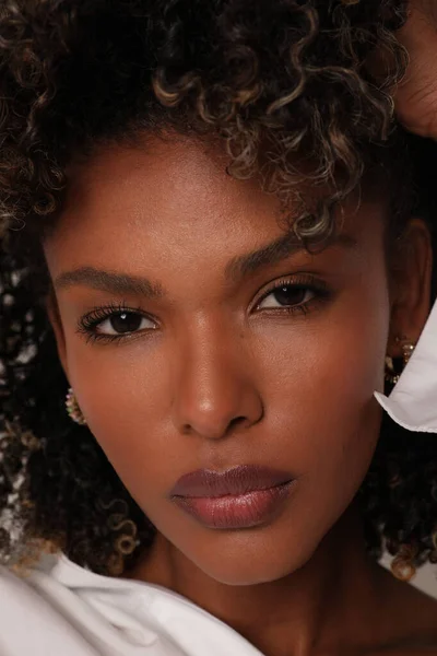 Close up de bela mulher jovem étnica com cabelo encaracolado posando na parede branca — Fotografia de Stock