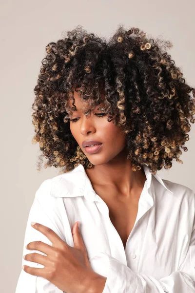 Kıvırcık siyah saçlı, güzel, etnik bir genç kadının dikey fotoğrafı. İzole edilmiş