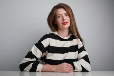 Kameraya bakıp arka planda poz veren genç bir kadının portresi.. 