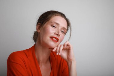 Gülümseyen genç kadın kameraya bakıyor, arka planda poz veriyor.. 