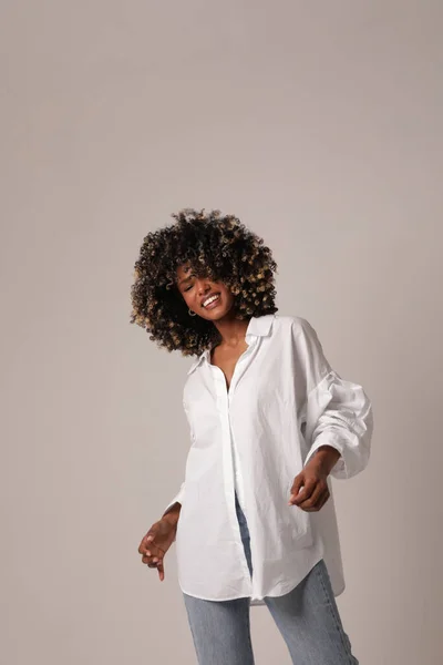 Jolie jeune femme noire posant dans le studio blanc. Photo verticale. — Photo