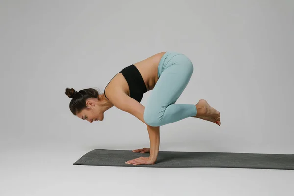 Ung kvinna som utövar yoga asana i klassen. Lugna dig och slappna av. Vertikal. — Stockfoto