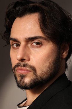 Kameraya bakan sakallı gencin dikey portresi. Dikey.