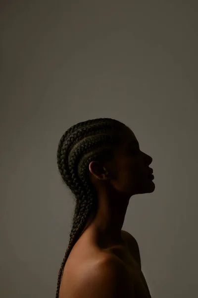 Siyah duvarda örgü ören Afrikalı genç bir kadının dikey portresi.. — Stok fotoğraf