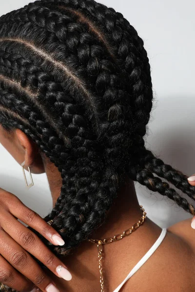 Vertical close-up of African woman with braids posing on white background. — Stock Photo, Image