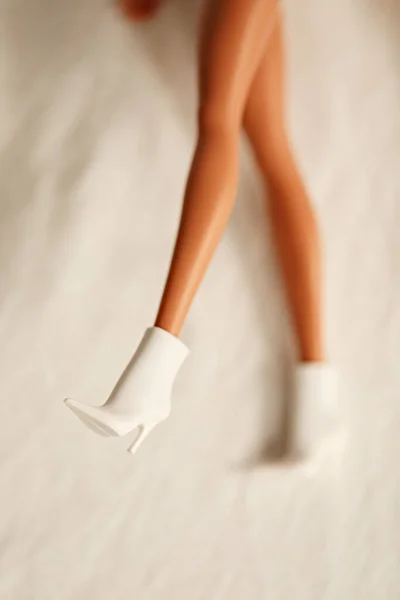 Pernas de boneca com sapatos isolados no fundo branco. Conceito mínimo criativo. — Fotografia de Stock