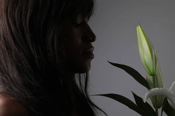 İris çiçeği tutan şehvetli kadının yakın plan portresi. Gri duvarda izole edilmiş.. — Stok fotoğraf