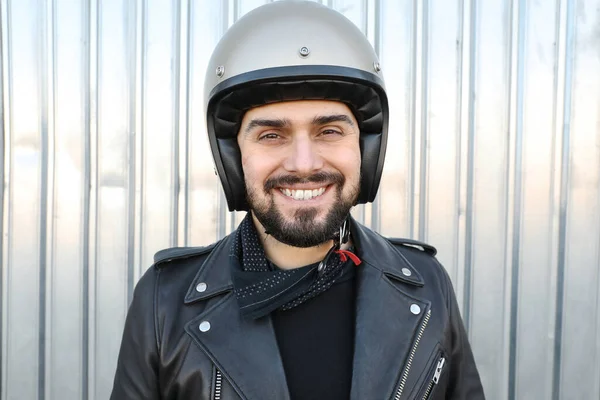Outdoor portrait of biker man posing in leather jacket and motorcycle helmet. — Foto de Stock