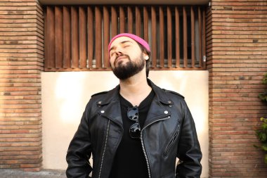 Deri ceketli ve bereli mutlu hippi adam. Açık havada portre.