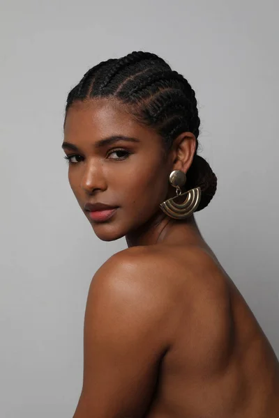 Portrait of African young woman with braids hairstyle posing on grey wall. — Foto de Stock