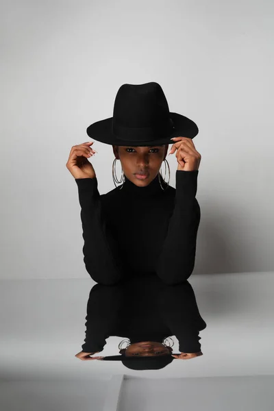 Jeune femme africaine élégante porte un chapeau noir et posant à l'intérieur. Vertical. — Photo